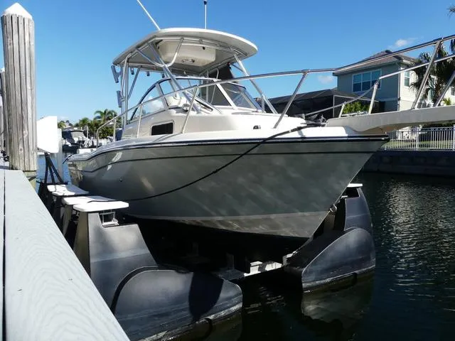 Slide: The Image of 2022 Grady-White Adventure 208 boat docked on a lift in a sunny marina. - 3