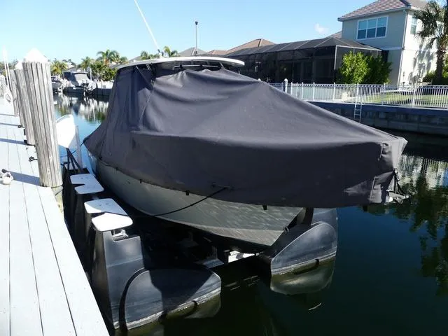 Slide: The Image of 2022 Grady-White Adventure 208 boat covered at dockside in sunny canal setting. - 7