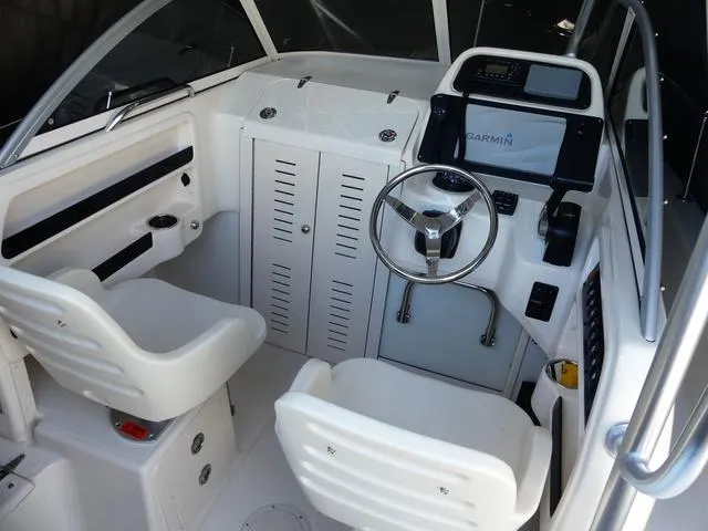Slide: The Image of 2022 Grady-White Adventure 208 boat interior with steering wheel and seating. - 9