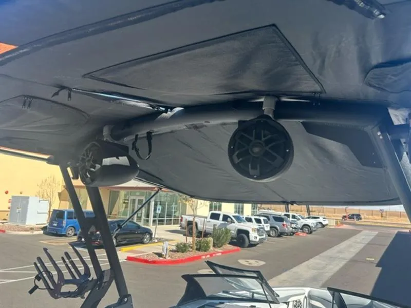 Slide: The Image of 2023 Axis T235 boat with mounted speakers and canopy in a parking lot. - 11