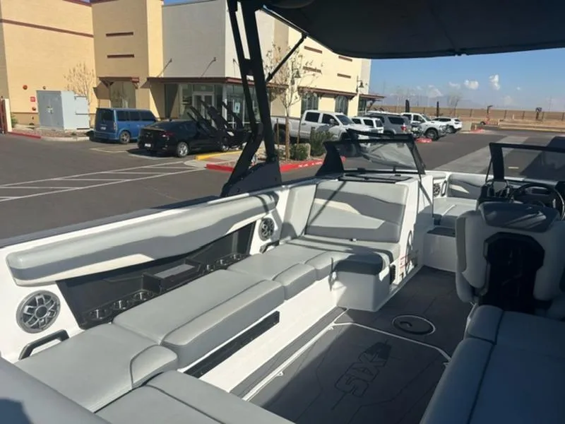 Slide: The Image of 2023 Axis T235 boat interior with gray seating in a parking lot. - 16