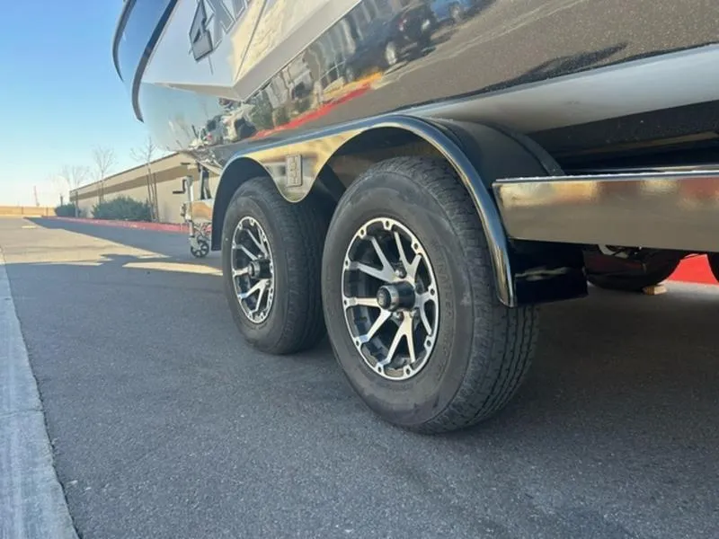 Slide: The Image of 2023 Axis T235 boat trailer with dual wheels on a paved road. - 6