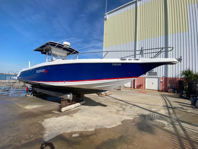 The Image of 2000 Donzi 35 ZF Open boat on dry dock, blue hull, sunny day. - 1