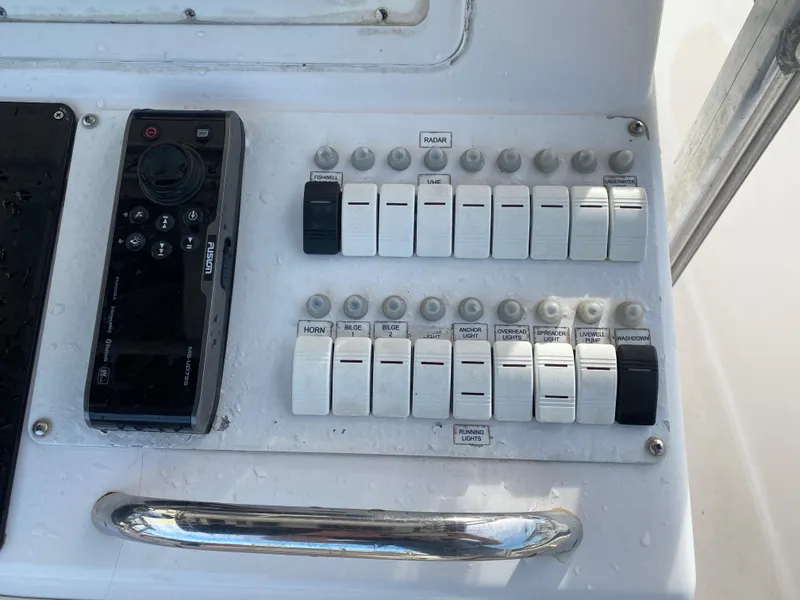 Slide: The Image of Control panel of a 2000 Donzi 35 ZF Open boat with switches and a remote. - 18