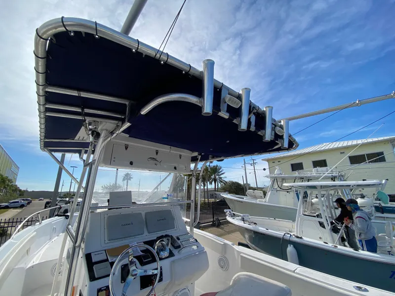 Slide: The Image of 2000 Donzi 35 ZF Open boat with T-top and steering console, docked under blue sky. - 23