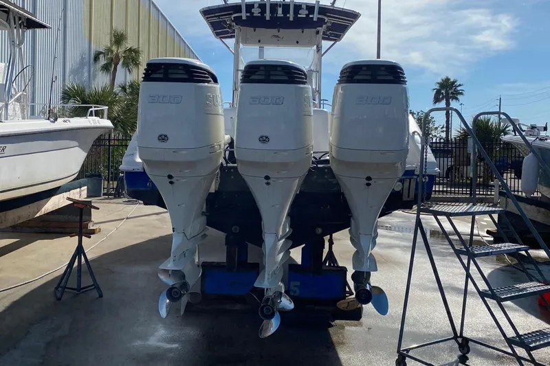 Slide: The Image of 2000 Donzi 35 ZF Open with triple outboard engines in a marina setting. - 7