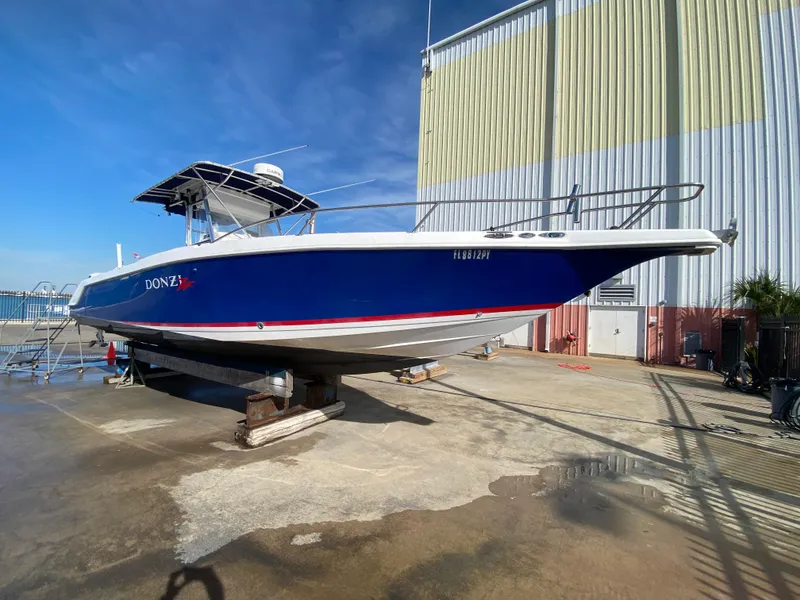 Slide: The Image of 2000 Donzi 35 ZF Open boat on dry dock, blue hull, sunny day. - 9