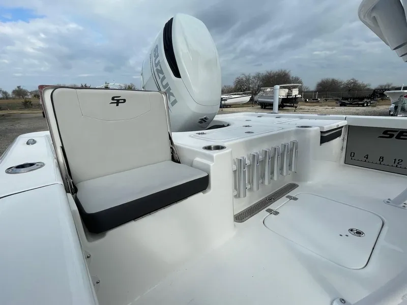 Slide: The Image of Seapro 230 boat interior, 2025 model, featuring seating and rod holders under a cloudy sky. - 7