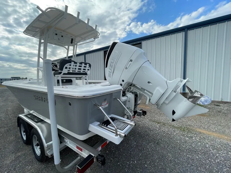 Slide: The Image of 2025 Seapro 230 boat on trailer with powerful outboard motor, parked near warehouse. - 8