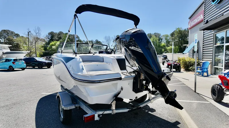 Slide: The Image of 2025 Bayliner M17 boat on trailer, parked outdoors near dealership. - 3