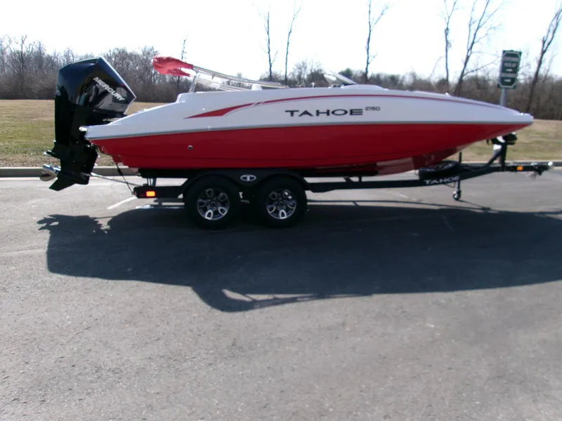 The Image of 2025 Tahoe 2150 boat on trailer, red and white design, parked outdoors. - 0