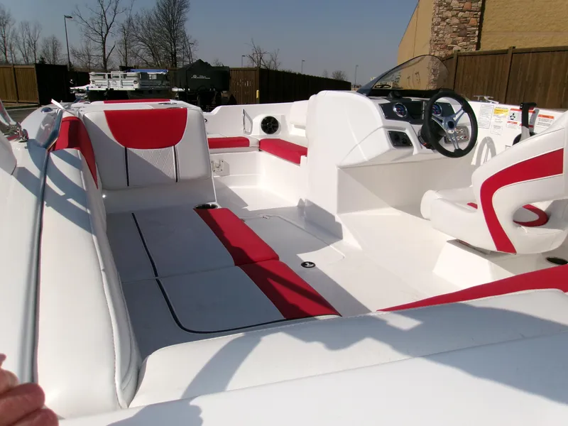 Slide: The Image of 2025 Tahoe 2150 boat interior with red and white seating, steering wheel, and dashboard. - 3