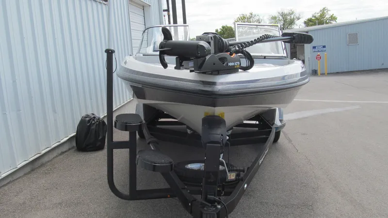 Slide: The Image of 2025 Ranger 212LS boat on trailer, parked near industrial building. - 13