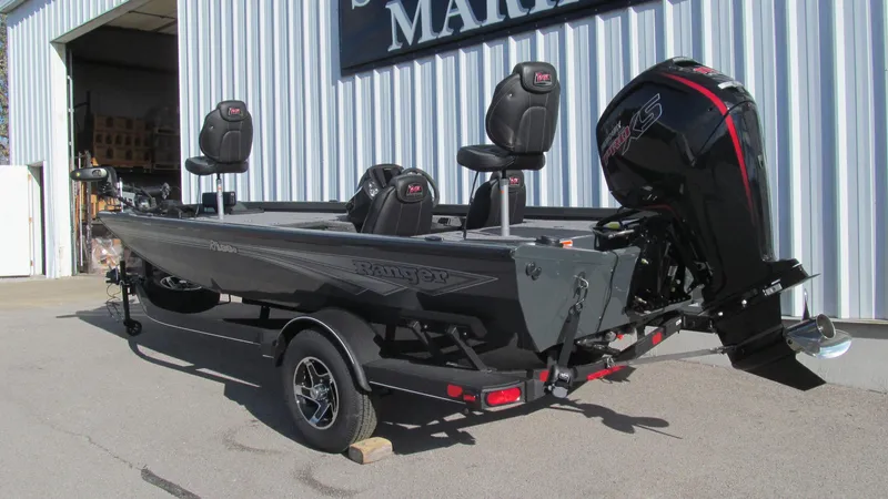 Slide: The Image of 2025 Ranger RT188C fishing boat with outboard motor, parked outside a marine shop. - 3