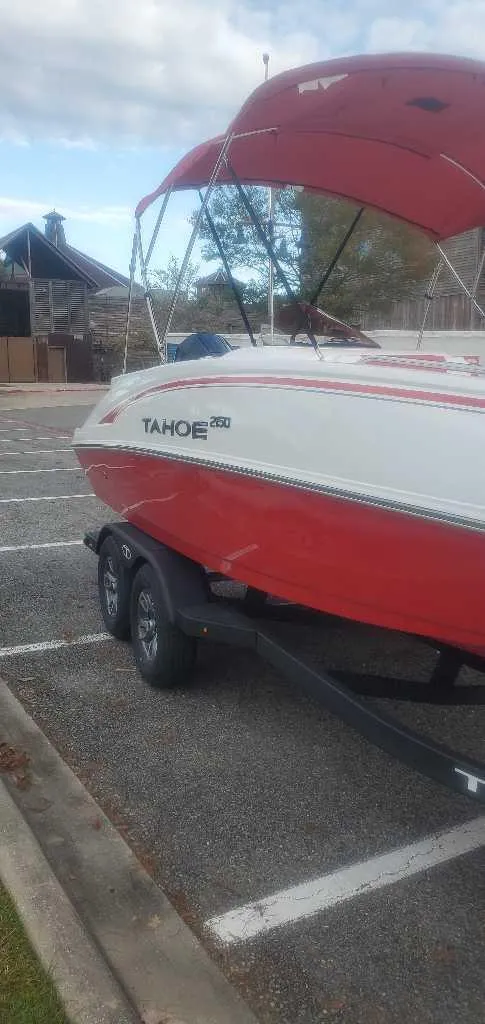 Slide: The Image of 2025 Tahoe 2150 boat interior with red and white seating, under a red canopy. - 4