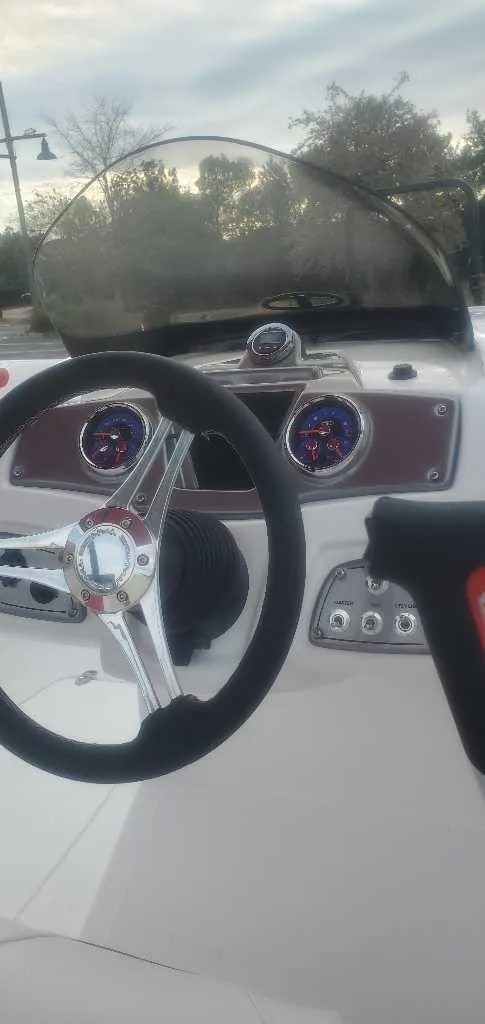 Slide: The Image of 2025 Tahoe 2150 boat interior storage compartment with red seating and cup holder. - 5