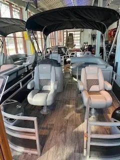 Slide: The Image of 2025 Ranger Reata 223F pontoon boat interior with plush seating and canopy. - 0