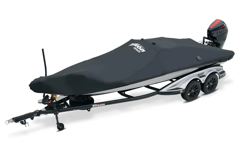 Slide: The Image of 2025 Triton 21XP Patriot boat on trailer, parked outside a blue building. - 7