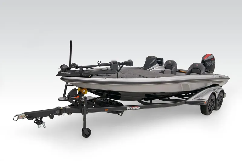Slide: The Image of 2025 Triton 21XP Patriot boat on trailer, parked outside a blue building. - 8