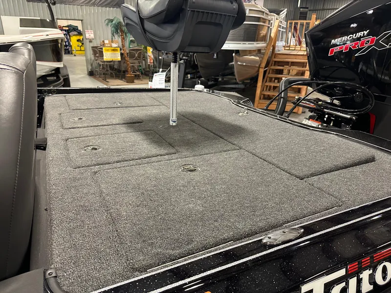 Slide: The Image of 2025 Triton 21XP Patriot boat deck with seating and Mercury engine in showroom. - 10