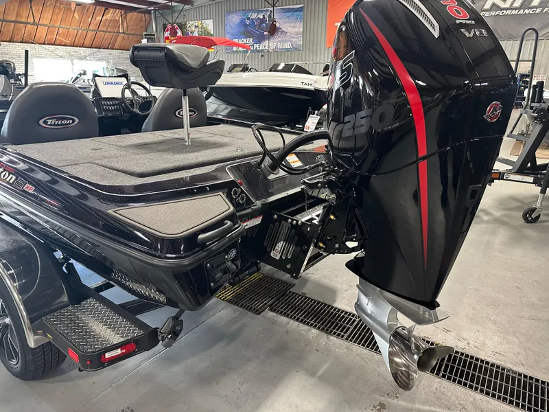 Slide: The Image of 2025 Triton 21XP Patriot boat with powerful outboard motor in showroom. - 11