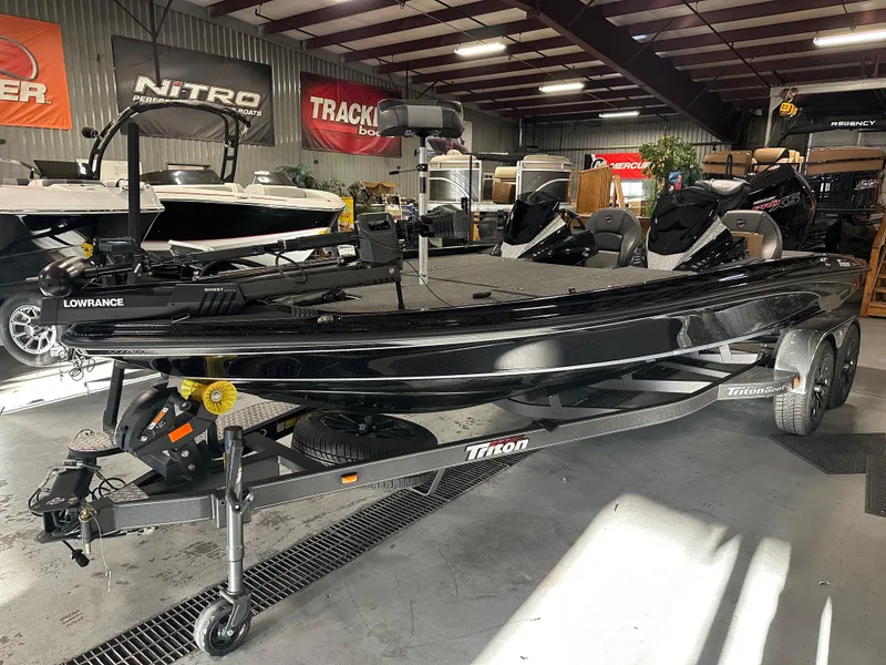 Slide: The Image of 2025 Triton 21XP Patriot boat in showroom, black exterior, on trailer. - 2