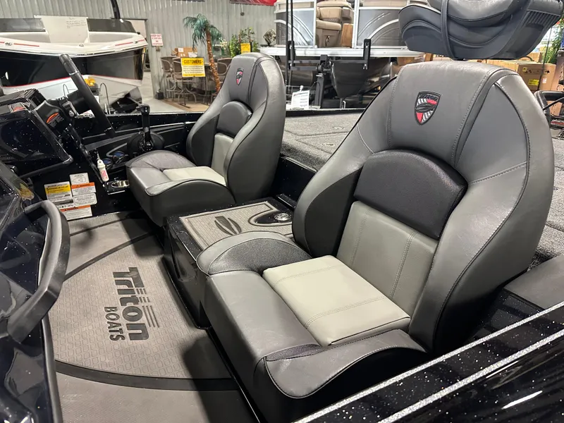 Slide: The Image of 2025 Triton 21XP Patriot boat interior with two gray seats and branded floor mat. - 8