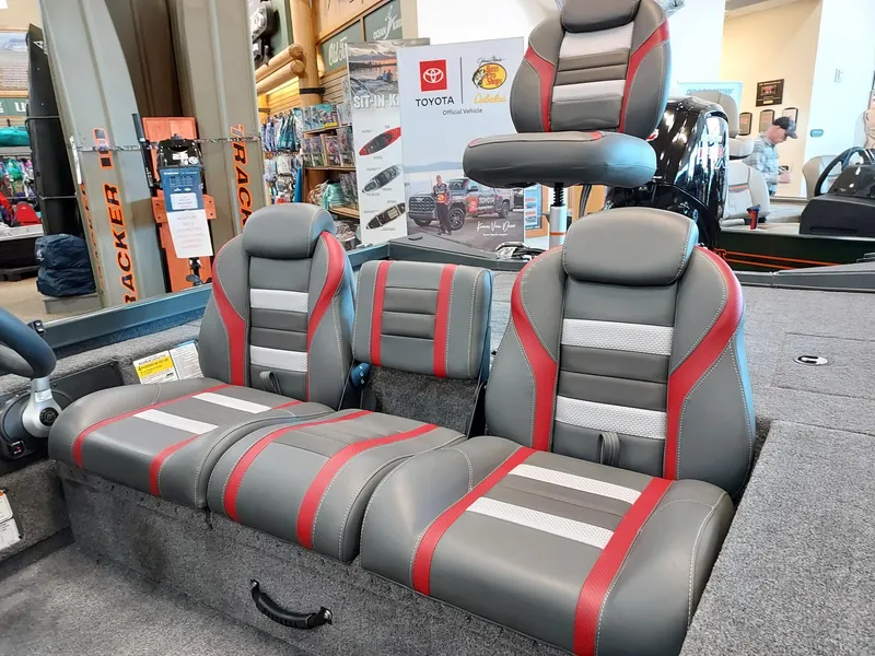 Slide: The Image of 2025 Ranger RT188C boat interior with gray and red seats in showroom. - 2