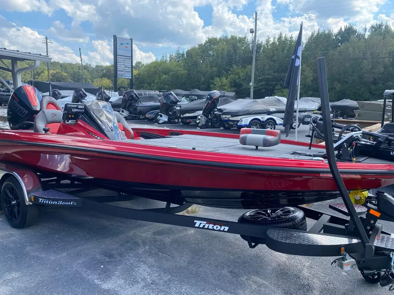 The Image of 2025 Triton 21XP Patriot boat in vibrant red on a trailer, displayed outdoors. - 0
