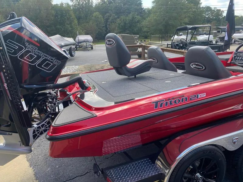 Slide: The Image of 2025 Triton 21XP Patriot boat with Racing 300 engine, red exterior, parked outdoors. - 6
