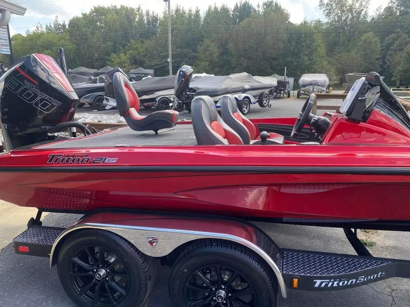 Slide: The Image of 2025 Triton 21XP Patriot boat in vibrant red with sleek design and powerful engine. - 8