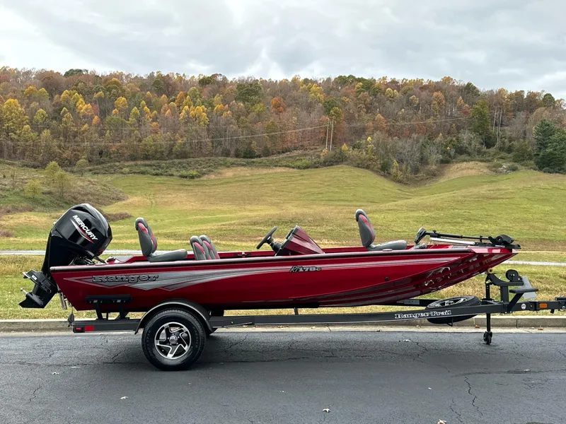 The Image of 2025 Ranger RT178C boat on trailer, red color, parked outdoors with scenic background. - 0