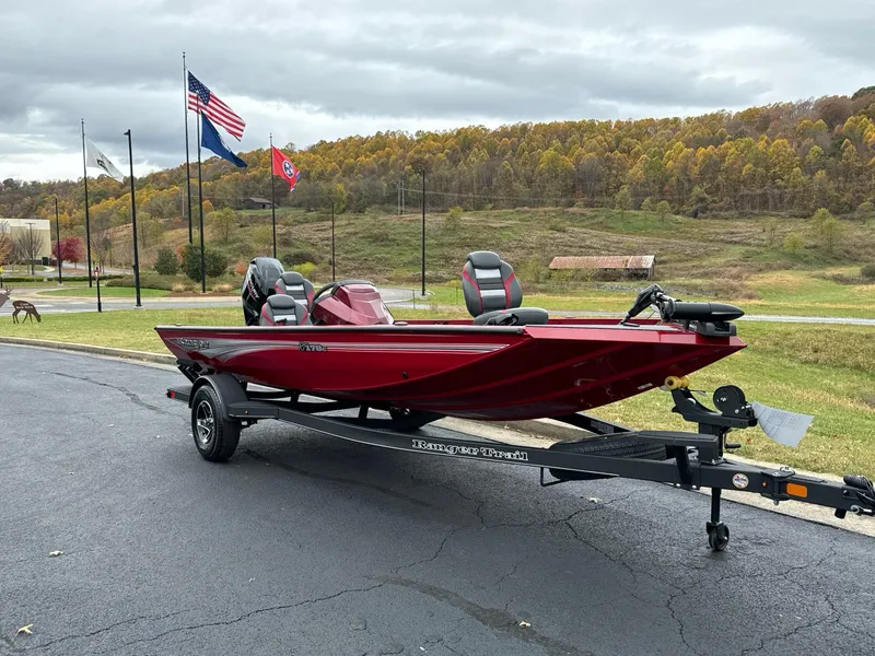 Slide: The Image of 2025 Ranger RT178C boat on trailer, parked near flags and scenic landscape. - 1