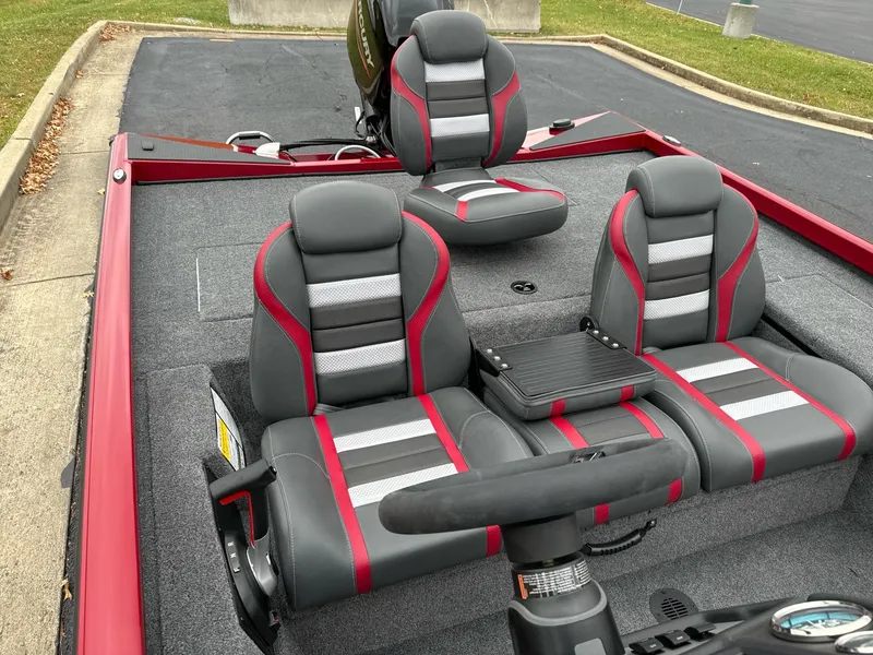 Slide: The Image of 2025 Ranger RT178C boat interior with red and gray seating, steering wheel, and carpeted deck. - 6