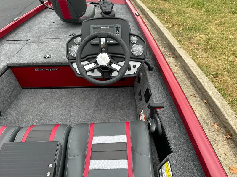 Slide: The Image of 2025 Ranger RT178C boat interior with steering wheel and seating, featuring red and gray accents. - 8