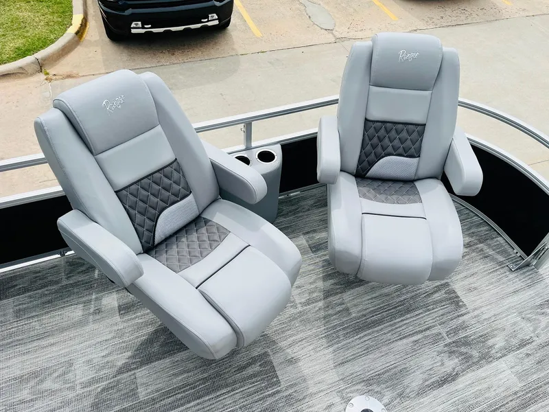 Slide: The Image of 2025 Ranger Reata 223FC boat seats, gray upholstery, diamond pattern, cup holders, outdoor setting. - 12