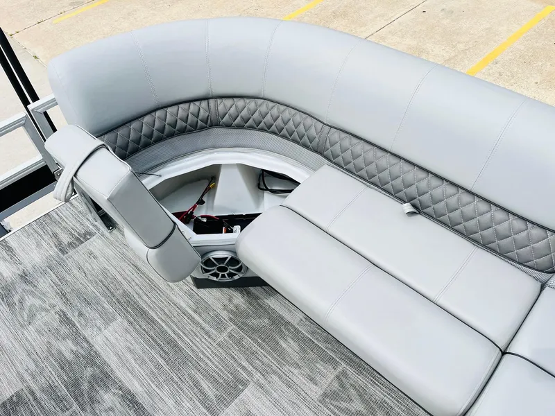 Slide: The Image of 2025 Ranger Reata 223FC boat interior with gray quilted seating and storage compartment. - 17