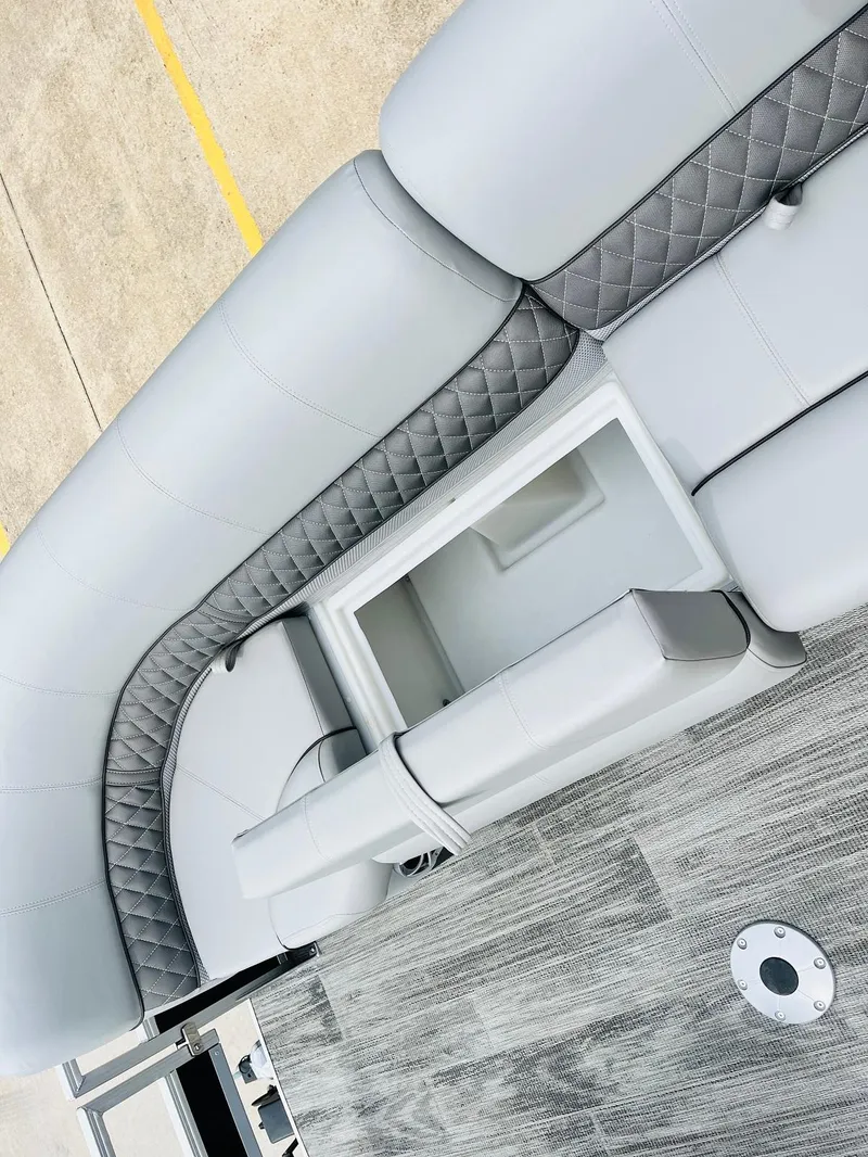 Slide: The Image of 2025 Ranger Reata 223FC boat interior with gray quilted seating and storage compartment. - 19
