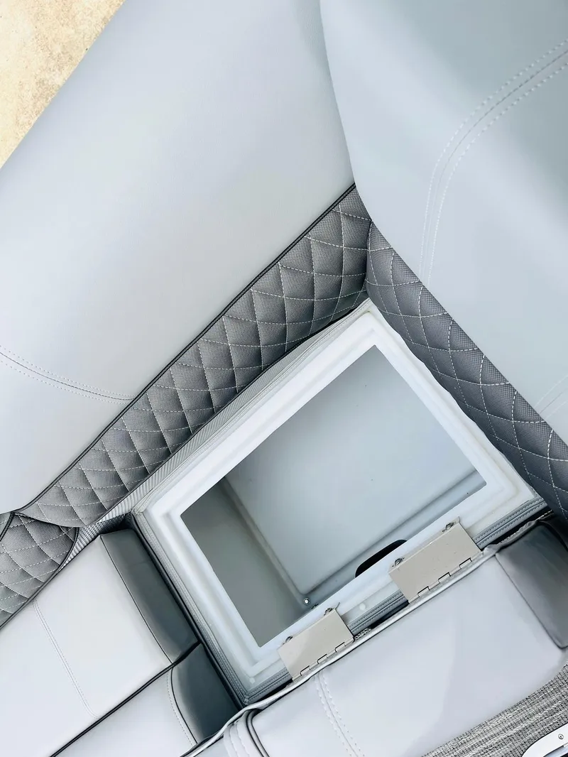 Slide: The Image of 2025 Ranger Reata 223FC interior with quilted gray seating and built-in storage compartment. - 20