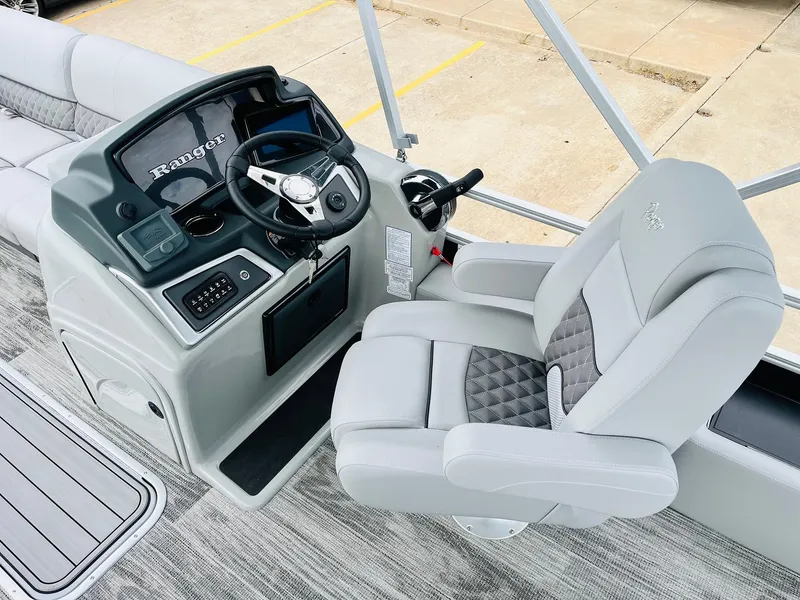 Slide: The Image of 2025 Ranger Reata 223FC boat interior with steering console and plush captain's chair. - 31