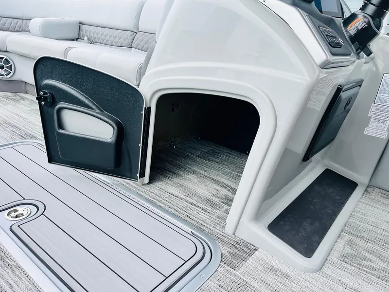 Slide: The Image of 2025 Ranger Reata 223FC boat interior with open storage compartment and seating area. - 32