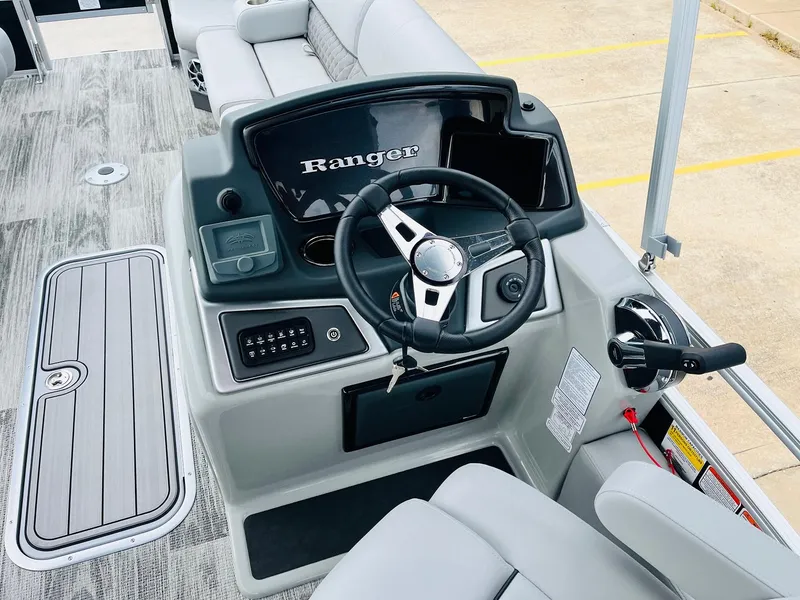 Slide: The Image of 2025 Ranger Reata 223FC boat dashboard with steering wheel and controls. - 33