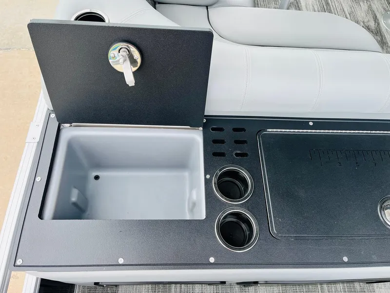 Slide: The Image of 2025 Ranger Reata 223FC boat console with storage, cup holders, and measuring board. - 44