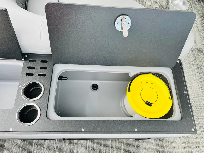 Slide: The Image of 2025 Ranger Reata 223FC boat storage compartment with cup holders and yellow lid. - 45
