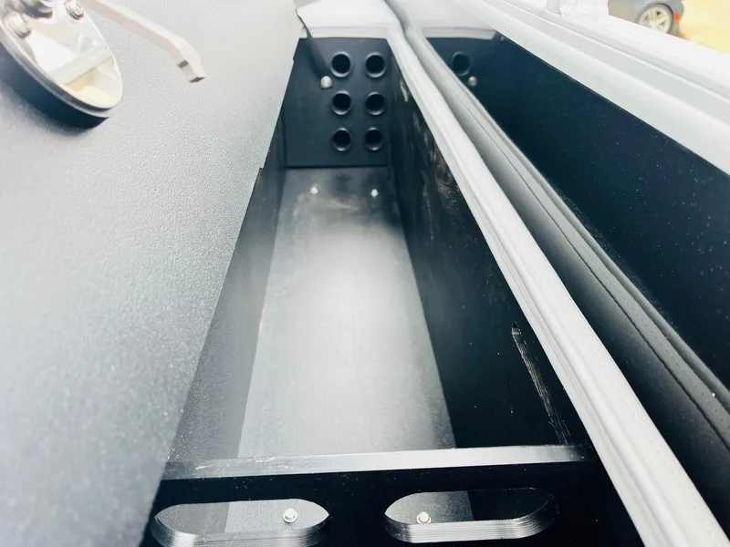 Slide: The Image of 2025 Ranger Reata 223FC storage compartment with sleek black interior design. - 48