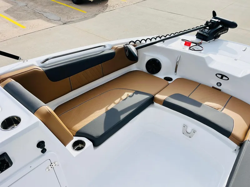 Slide: The Image of 2025 Tahoe 2150 boat interior with tan and black seating, cup holders, and control panel. - 13