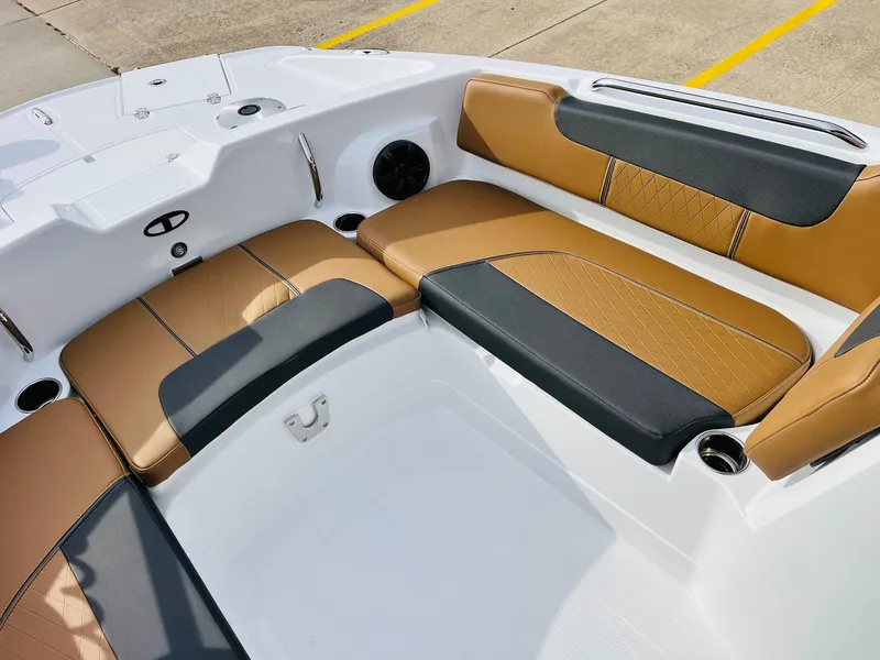 Slide: The Image of 2025 Tahoe 2150 boat interior with tan and black seating, cup holders, and speaker. - 14