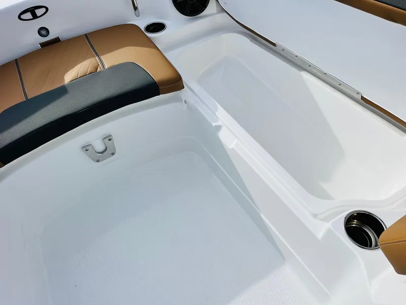 Slide: The Image of 2025 Tahoe 2150 boat interior with tan and black seating, white deck, and cup holders. - 17