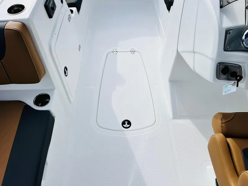 Slide: The Image of Interior view of 2025 Tahoe 2150 boat, featuring sleek white deck and brown seating. - 25