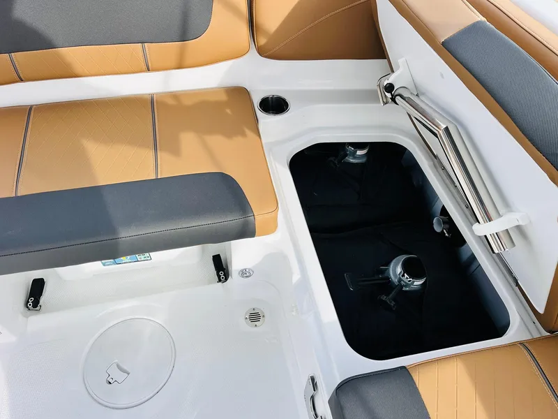 Slide: The Image of 2025 Tahoe 2150 boat interior with tan and gray seating, storage compartment open. - 28